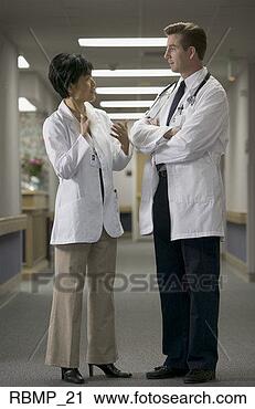 Stock Photography - two adult doctors 
stand together 
and talk back 
and forth in the. 
fotosearch - search 
stock photos, 
pictures, images, 
and photo clipart