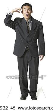 Stock Image - an adult asian 
business man in 
a dark suit ponts 
to his head and. 
fotosearch - search 
stock photos, 
pictures, images, 
and photo clipart