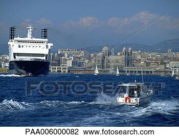 Stock Photo - ferry next to 
smaller moving 
boat, coastal 
city in background. 
fotosearch - search 
stock photos, 
pictures, images, 
and photo clipart