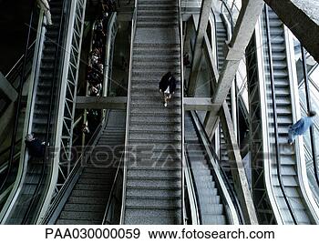 Stock Photograph - woman walking 
down steps in 
between escalators. 
fotosearch - search 
stock photos, 
pictures, images, 
and photo clipart