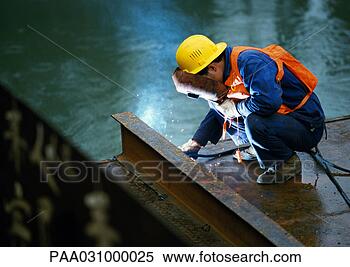 Stock Image - welder wearing 
welding mask, 
crouching and 
welding girder. 
fotosearch - search 
stock photos, 
pictures, images, 
and photo clipart