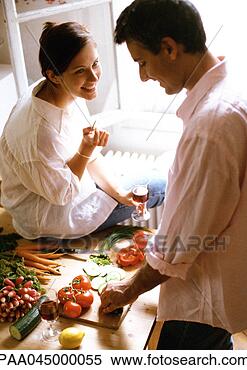 Stock Image - man chopping vegetables 
on table,  woman 
sitting on table, 
 holding. fotosearch 
- search stock 
photos, pictures, 
images, and photo 
clipart