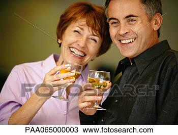 Stock Photo - man and woman 
smiling and holding 
up wine glasses, 
close up. fotosearch 
- search stock 
photos, pictures, 
images, and photo 
clipart