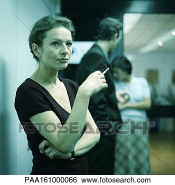Stock Photo - woman smoking, 
arms crossed, 
people in background. 
fotosearch - search 
stock photos, 
pictures, images, 
and photo clipart