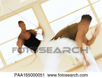 Stock Photography - two men performing 
capoeira, blurred. 
fotosearch - search 
stock photos, 
pictures, images, 
and photo clipart