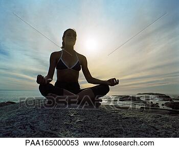 Stock Photo - woman sitting 
in lotus position, 
sky and seascape 
in background. 
fotosearch - search 
stock photos, 
pictures, images, 
and photo clipart