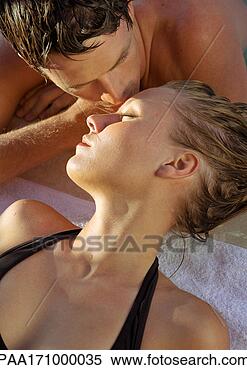 Stock Image - couple lying down, 
man kissing woman's 
forehead, close-up. 
fotosearch - search 
stock photos, 
pictures, images, 
and photo clipart