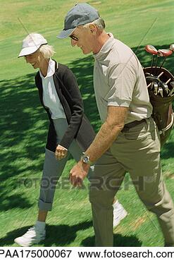 Picture - mature man and 
woman on green, 
man carrying golf 
clubs. fotosearch 
- search stock 
photos, pictures, 
images, and photo 
clipart
