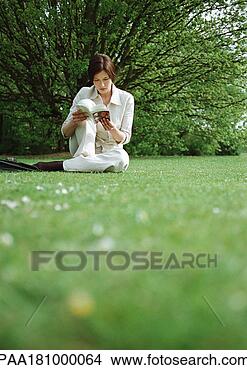 Stock Photo - woman sitting 
on grass, reading 
book. fotosearch 
- search stock 
photos, pictures, 
images, and photo 
clipart