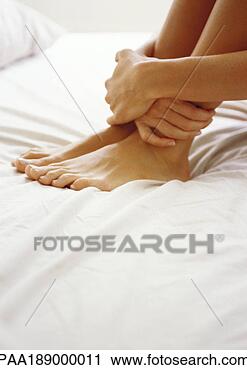 Stock Photography - woman holding 
ankles, close 
up. fotosearch 
- search stock 
photos, pictures, 
images, and photo 
clipart