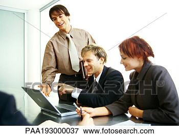 Picture - business people 
working together 
on laptop computer. 
fotosearch - search 
stock photos, 
pictures, images, 
and photo clipart