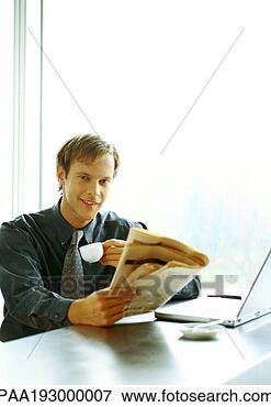 Picture - businessman sitting 
at desk, drinking 
and reading. fotosearch 
- search stock 
photos, pictures, 
images, and photo 
clipart