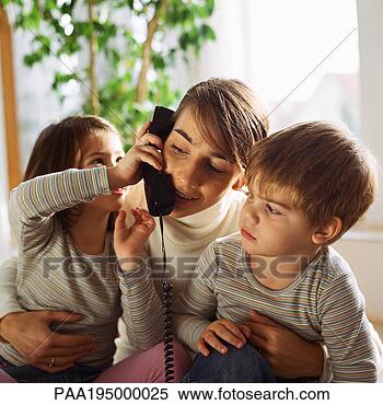 Stock Image - mother sitting 
with children, 
daughter holding 
phone to mother's 
ear. fotosearch 
- search stock 
photos, pictures, 
images, and photo 
clipart