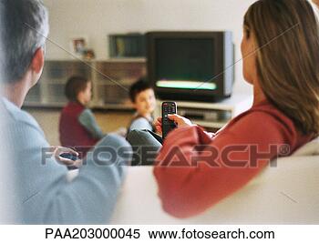 Stock Image - adult man and 
woman sitting 
on sofa,  rear 
view,  blurred 
in. fotosearch 
- search stock 
photos, pictures, 
images, and photo 
clipart