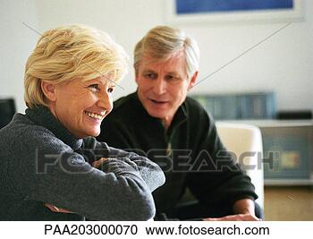 Stock Photography - senior woman sitting 
with arms folded 
across chest, 
 side view. fotosearch 
- search stock 
photos, pictures, 
images, and photo 
clipart