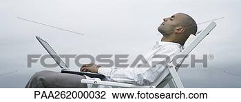Stock Photo - man with eyes 
closed in lounge 
chair with laptop 
on lap,  sky in. 
fotosearch - search 
stock photos, 
pictures, images, 
and photo clipart