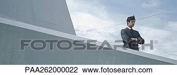 Stock Photo - man standing behind 
concrete wall 
with arms folded, 
low angle view. 
fotosearch - search 
stock photos, 
pictures, images, 
and photo clipart