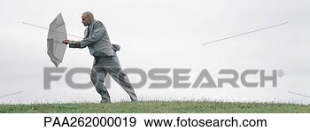 Stock Photograph - man walking into 
wind with open 
umbrella shielding 
him, full length. 
fotosearch - search 
stock photos, 
pictures, images, 
and photo clipart