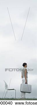 Stock Photography - woman standing 
on grass holding 
metallic briefcase 
in front of chair. 
fotosearch - search 
stock photos, 
pictures, images, 
and photo clipart