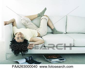 Stock Photography - woman lying on 
back on sofa, 
 head hanging 
upside down off 
sofa. fotosearch 
- search stock 
photos, pictures, 
images, and photo 
clipart