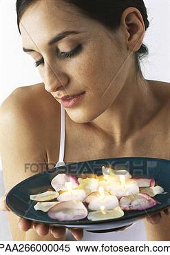 Stock Image - woman holding 
plate of candles 
and rose petals, 
looking down, 
close-up. fotosearch 
- search stock 
photos, pictures, 
images, and photo 
clipart