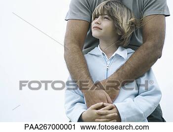 Stock Photography - boy standing with 
father's arms 
around him. fotosearch 
- search stock 
photos, pictures, 
images, and photo 
clipart