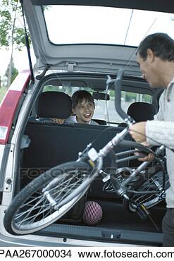 Stock Photo - man putting bicycle 
into trunk of 
car,  girl in 
car turning around. 
fotosearch - search 
stock photos, 
pictures, images, 
and photo clipart