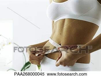 Stock Image - woman measuring 
waist, mid section. 
fotosearch - search 
stock photos, 
pictures, images, 
and photo clipart