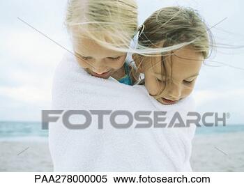 Stock Image - two girls wrapped 
in same towel 
on beach. fotosearch 
- search stock 
photos, pictures, 
images, and photo 
clipart