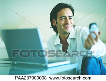 Stock Photo - man smiling and 
holding out cell 
phone. fotosearch 
- search stock 
photos, pictures, 
images, and photo 
clipart
