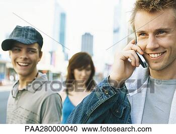 Stock Photography - young people in 
city setting, 
one young man 
using cell phone. 
fotosearch - search 
stock photos, 
pictures, images, 
and photo clipart