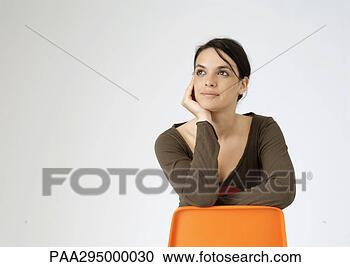 Stock Photography - young woman sitting 
backwards on chair, 
portrait. fotosearch 
- search stock 
photos, pictures, 
images, and photo 
clipart