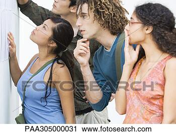 Stock Photography - students looking 
at results posted 
on wall, side 
view. fotosearch 
- search stock 
photos, pictures, 
images, and photo 
clipart