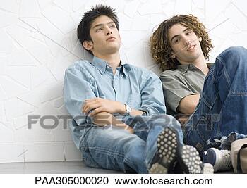 Stock Photography - two young men 
sitting on ground, 
leaning back against 
wall. fotosearch 
- search stock 
photos, pictures, 
images, and photo 
clipart