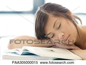 Stock Image - young woman resting 
head on books, 
with eyes closed. 
fotosearch - search 
stock photos, 
pictures, images, 
and photo clipart