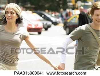 Stock Photography - young couple holding 
hands in busy 
street. fotosearch 
- search stock 
photos, pictures, 
images, and photo 
clipart