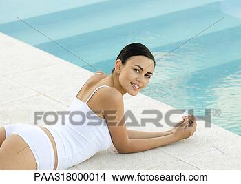 Stock Photo - woman lying by 
pool, smiling 
over shoulder 
at camera. fotosearch 
- search stock 
photos, pictures, 
images, and photo 
clipart