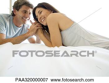Picture - adult couple lying 
face to face on 
bed. fotosearch 
- search stock 
photos, pictures, 
images, and photo 
clipart