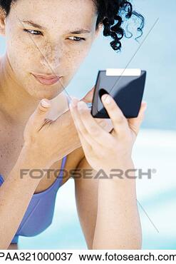 Picture - young woman looking 
at self in compact 
mirror. fotosearch 
- search stock 
photos, pictures, 
images, and photo 
clipart