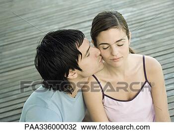 Stock Photo - young man kissing 
his girlfriend 
on the cheek, 
closed eyes, portrait. 
fotosearch - search 
stock photos, 
pictures, images, 
and photo clipart