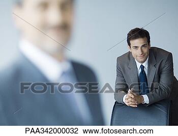 Stock Photo - businessman leaning 
on back of chair, 
focus on background. 
fotosearch - search 
stock photos, 
pictures, images, 
and photo clipart