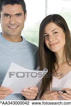 Stock Photo - couple holding 
document and calculator, 
smiling at camera. 
fotosearch - search 
stock photos, 
pictures, images, 
and photo clipart