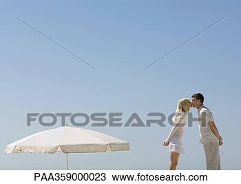 Stock Photo - couple kissing 
next to parasol. 
fotosearch - search 
stock photos, 
pictures, images, 
and photo clipart