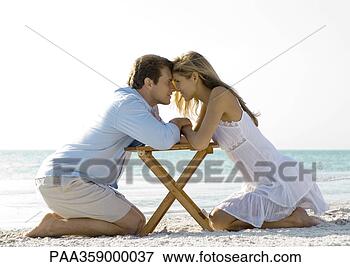Picture - couple kneeling 
on beach, nose 
to nose. fotosearch 
- search stock 
photos, pictures, 
images, and photo 
clipart