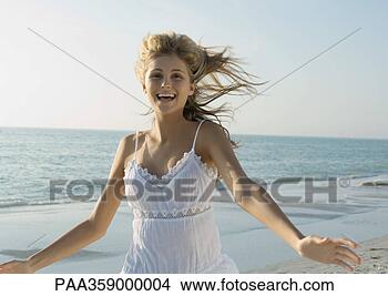 Stock Photo - young woman running 
with arms out 
on beach. fotosearch 
- search stock 
photos, pictures, 
images, and photo 
clipart