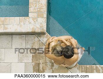 Stock Image - couple sitting 
on edge of pool 
together. fotosearch 
- search stock 
photos, pictures, 
images, and photo 
clipart