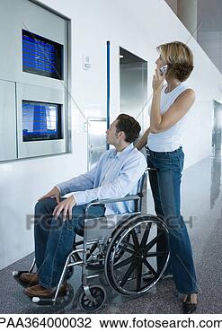 Stock Photo - woman and man 
in wheelchair 
looking at departure 
board in airport. 
fotosearch - search 
stock photos, 
pictures, images, 
and photo clipart