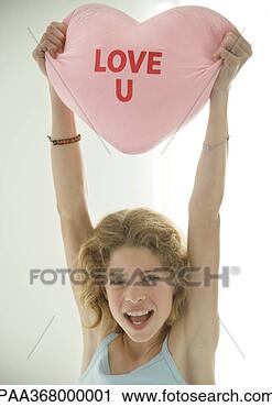 Stock Photography - preteen girl holding 
up heart shaped 
pillow. fotosearch 
- search stock 
photos, pictures, 
images, and photo 
clipart