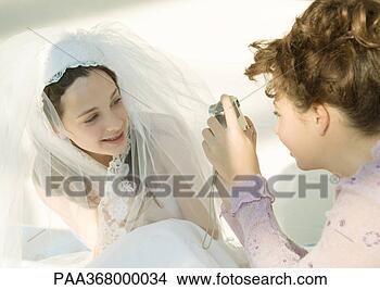Stock Photo - preteen girl taking 
photo of friend 
dressed in wedding 
dress. fotosearch 
- search stock 
photos, pictures, 
images, and photo 
clipart