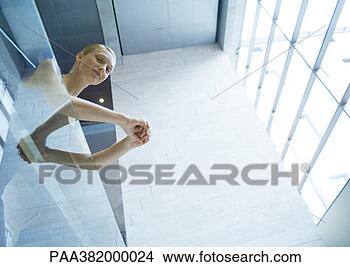 Stock Photo - businesswoman 
leaning against 
balcony, low angle 
view. fotosearch 
- search stock 
photos, pictures, 
images, and photo 
clipart
